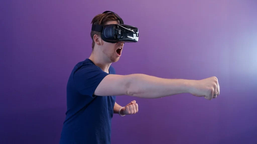 man punching air while wearing VR googles